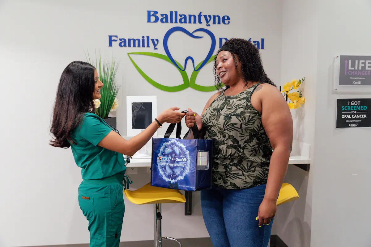 Dr. Patel greeting a patient at the Ballantyne Family Dentistry front desk